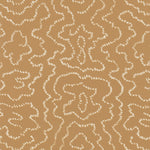 Detail of wallpaper in a minimalist wood grain print in cream on a tan field.