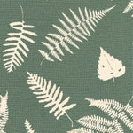 Detail of fabric in a repeating fern and dragonfly print in cream on a dark green field.