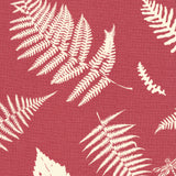 Detail of fabric in a repeating fern and dragonfly print in cream on a red field.