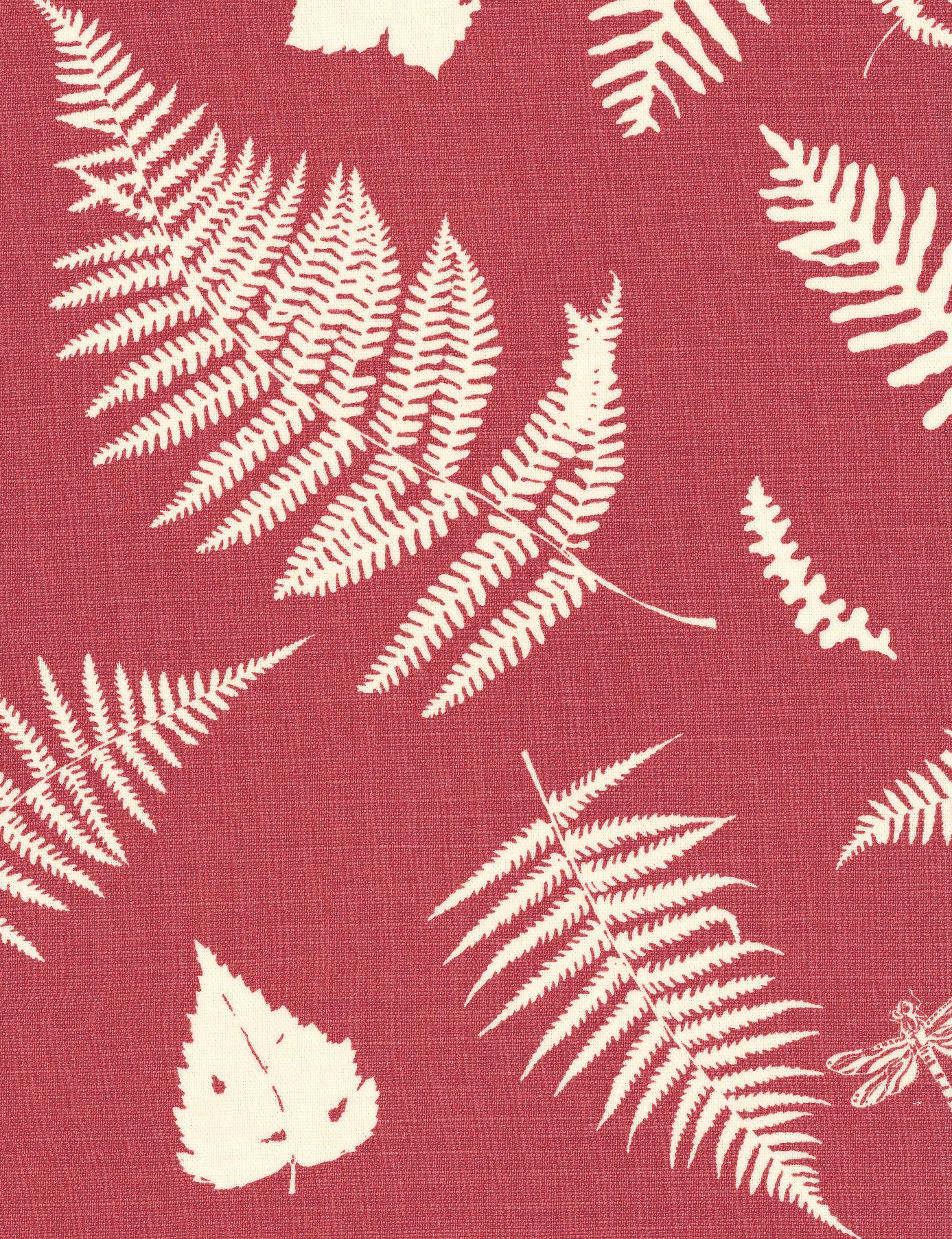 Detail of fabric in a repeating fern and dragonfly print in cream on a red field.