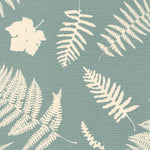 Detail of fabric in a repeating fern and dragonfly print in cream on a turquoise field.