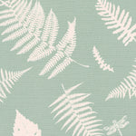 Detail of fabric in a repeating fern and dragonfly print in cream on a light green field.