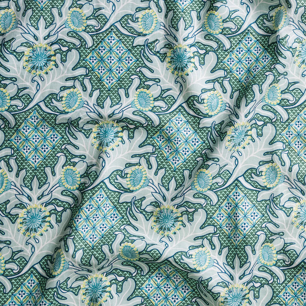 Draped fabric in a dense print mixing geometric and botanical motifs in turquoise, yellow and light aqua