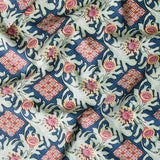 Draped fabric in a dense print mixing geometric and botanical motifs in blue, red, pale green and yellow