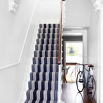 Striped flatweave runner in black and white on white staircase