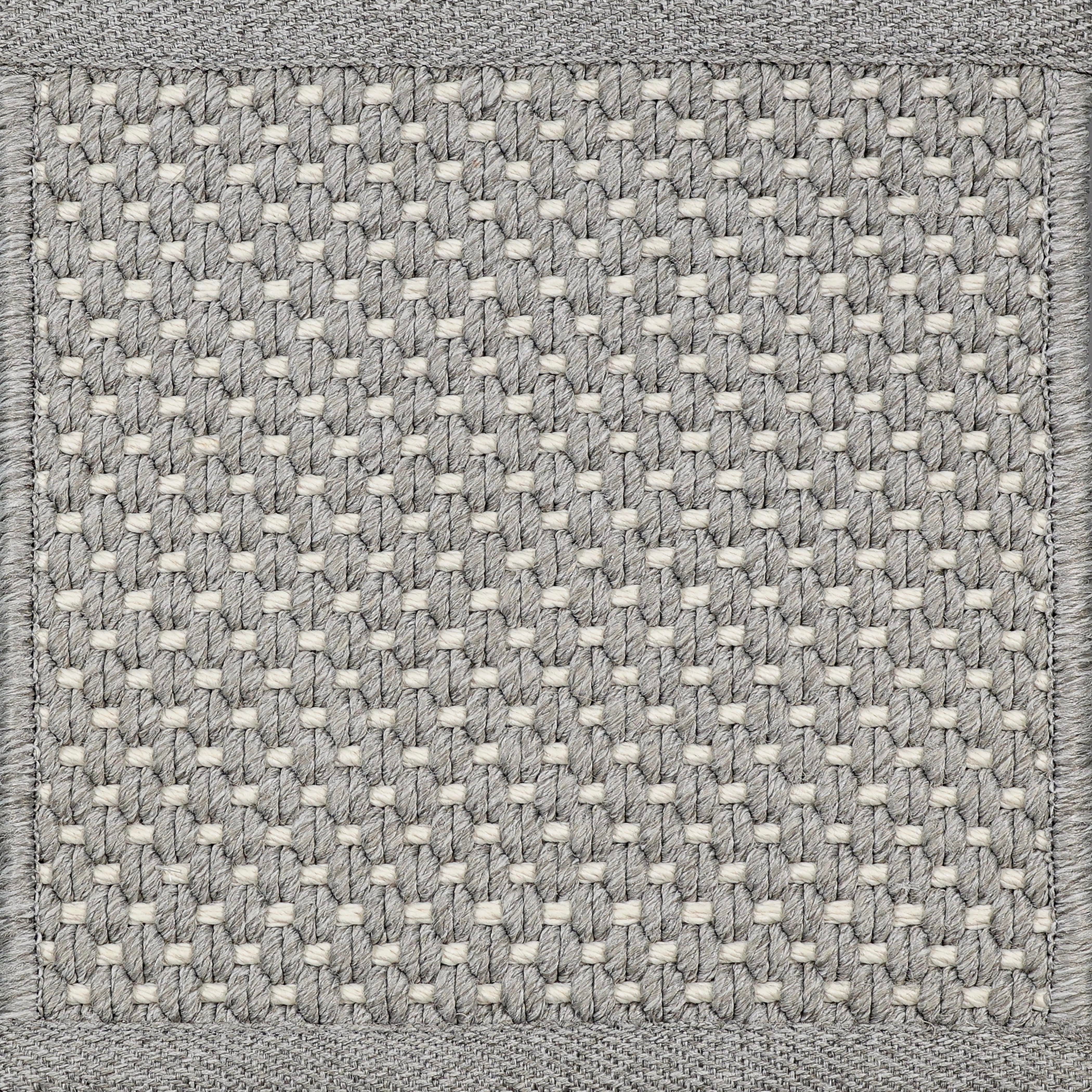 Close-up of woven carpet with a grid pattern in gray and white.