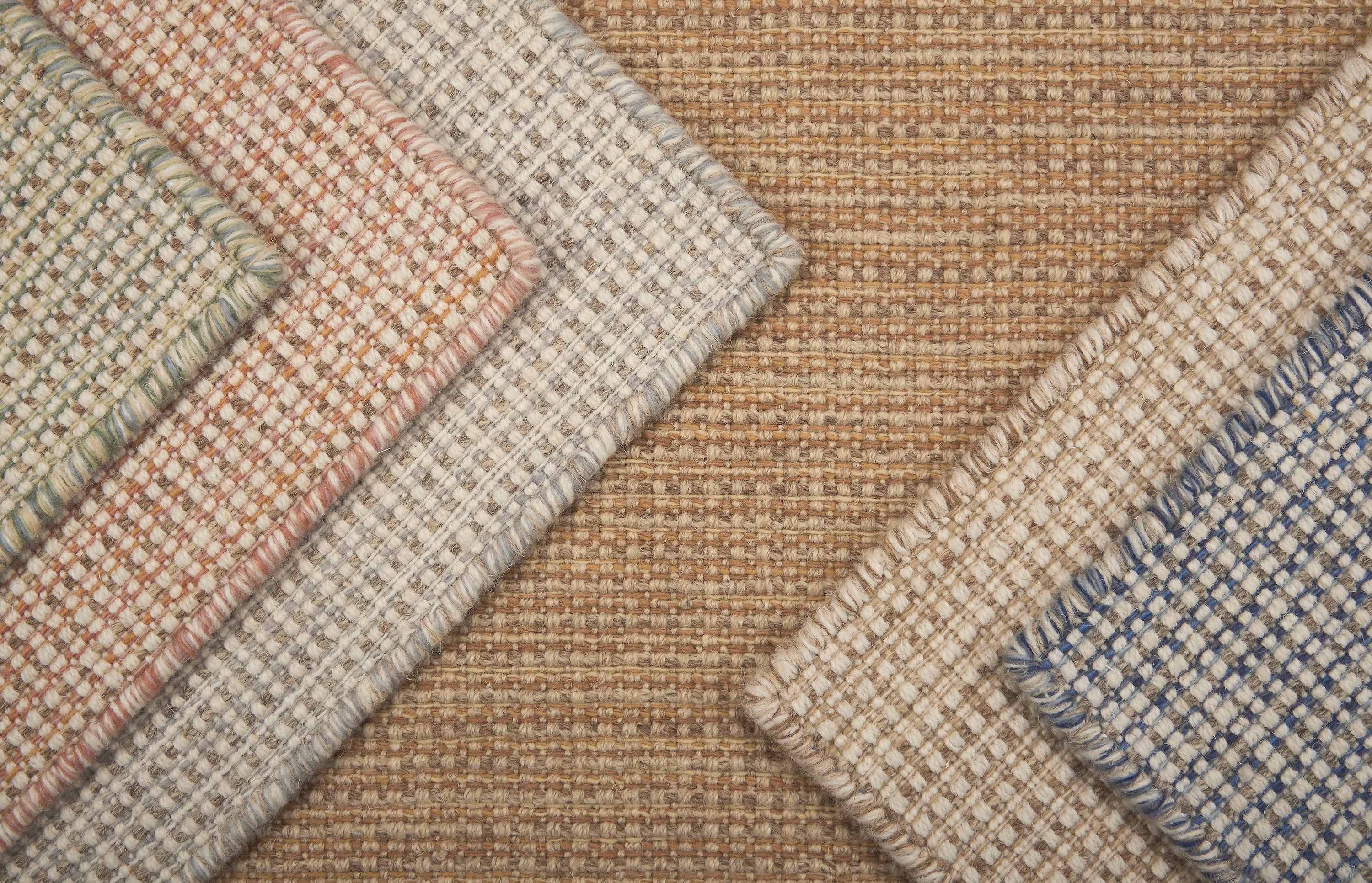 Close-up of various textured rugs with different patterns and colors.