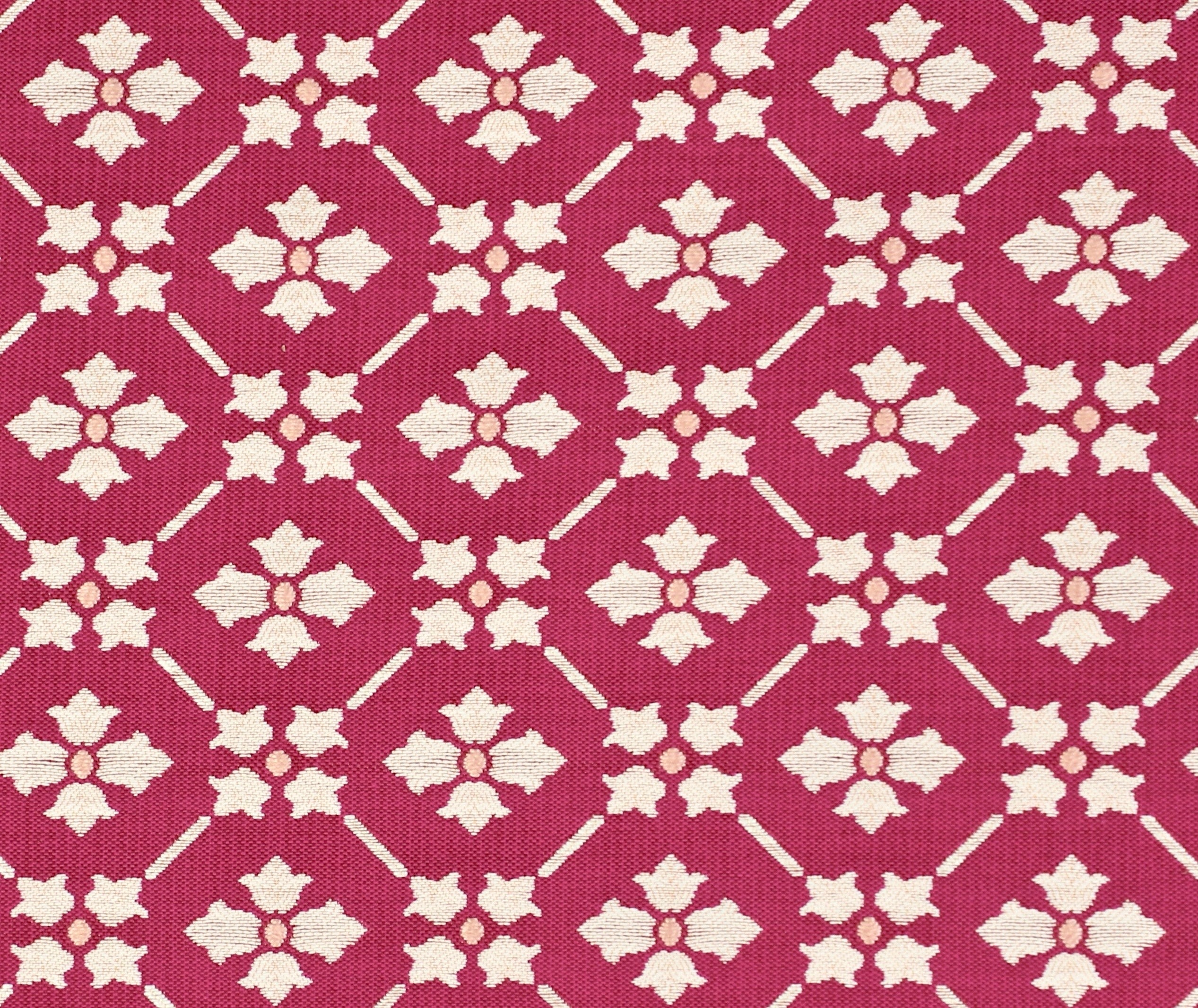 Detail of fabric in a repeating floral lattice print in white and coral on a magenta field.