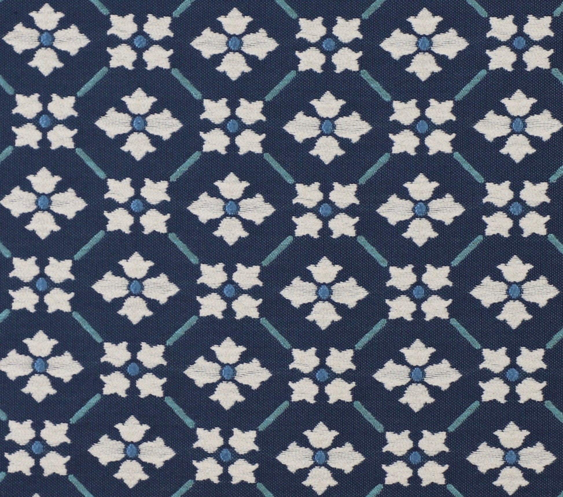 Detail of fabric in a repeating floral lattice print in blue and cream on a navy field.