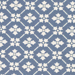 Detail of fabric in a repeating floral lattice print in cream on a blue field.