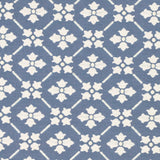 Detail of fabric in a repeating floral lattice print in cream on a blue field.