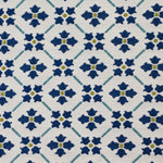 Detail of fabric in a repeating floral lattice print in blue and gold on a cream field.