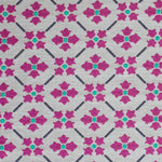 Detail of fabric in a repeating floral lattice print in magenta and turquoise on a greige field.