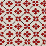 Detail of fabric in a repeating floral lattice print in red and brown on a cream field.