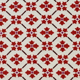 Detail of fabric in a repeating floral lattice print in red and brown on a cream field.