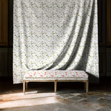 Decorative bench with floral pattern in front of a curtain with similar design