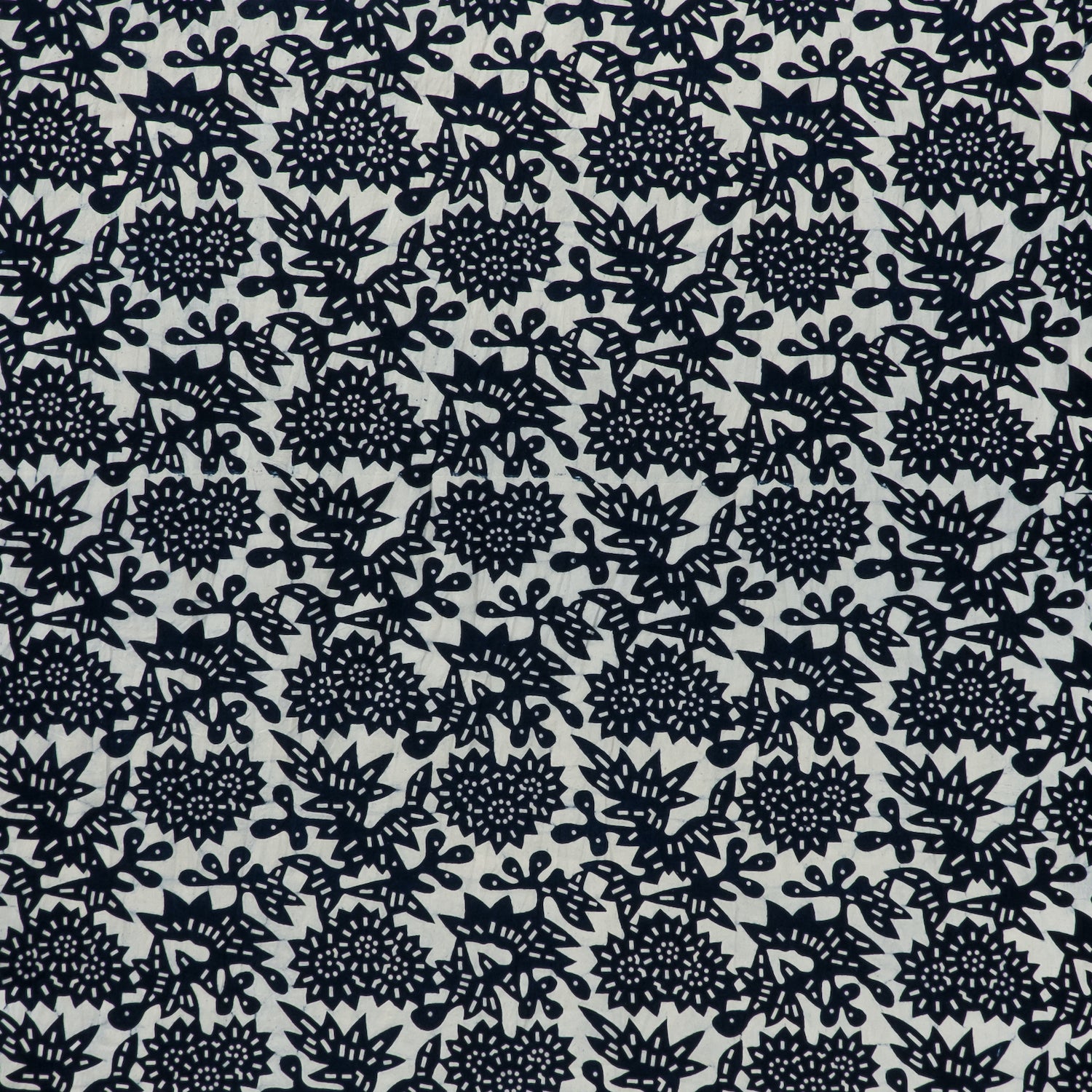 printed linen-cotton fabric in a repeating geometric flower pattern in indigo on a white field.