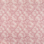 Detail of fabric in a dense petal print in shades of pink on a white field.