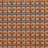Patterned fabric with a gridded floral design in pastel orange, blue and brown. 
