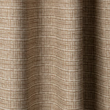 Draped linen fabric in a repeating abstract gridded pattern in tan on a cream field.