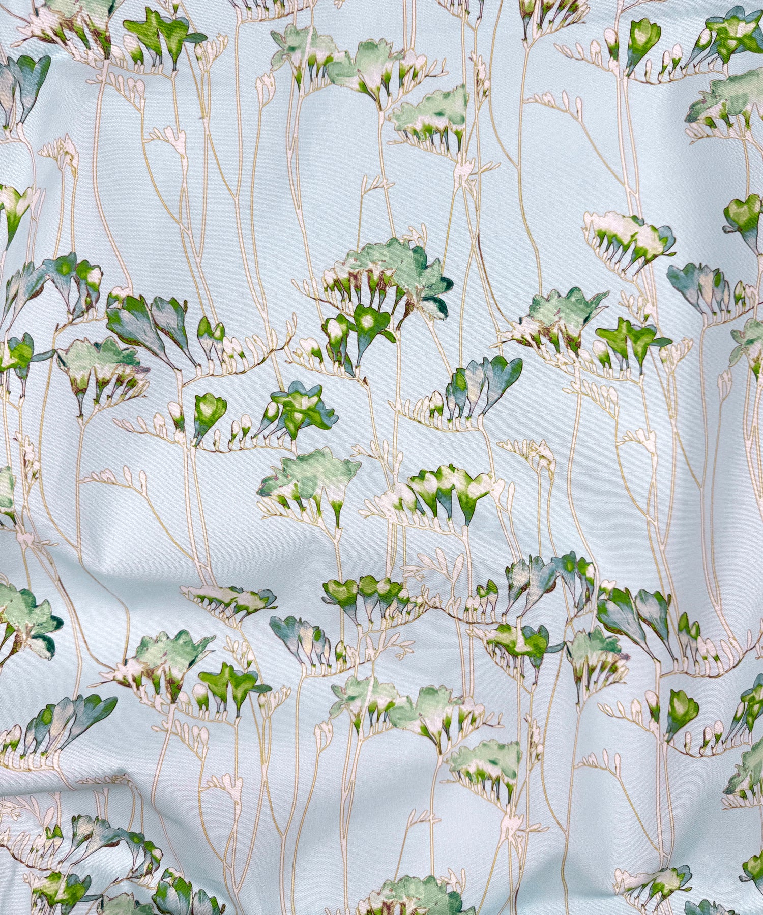 Floral pattern with green leaves and beige stems on a light blue background