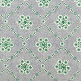 Detail of wallpaper in an intricate floral lattice print in green and gray on a cream field.