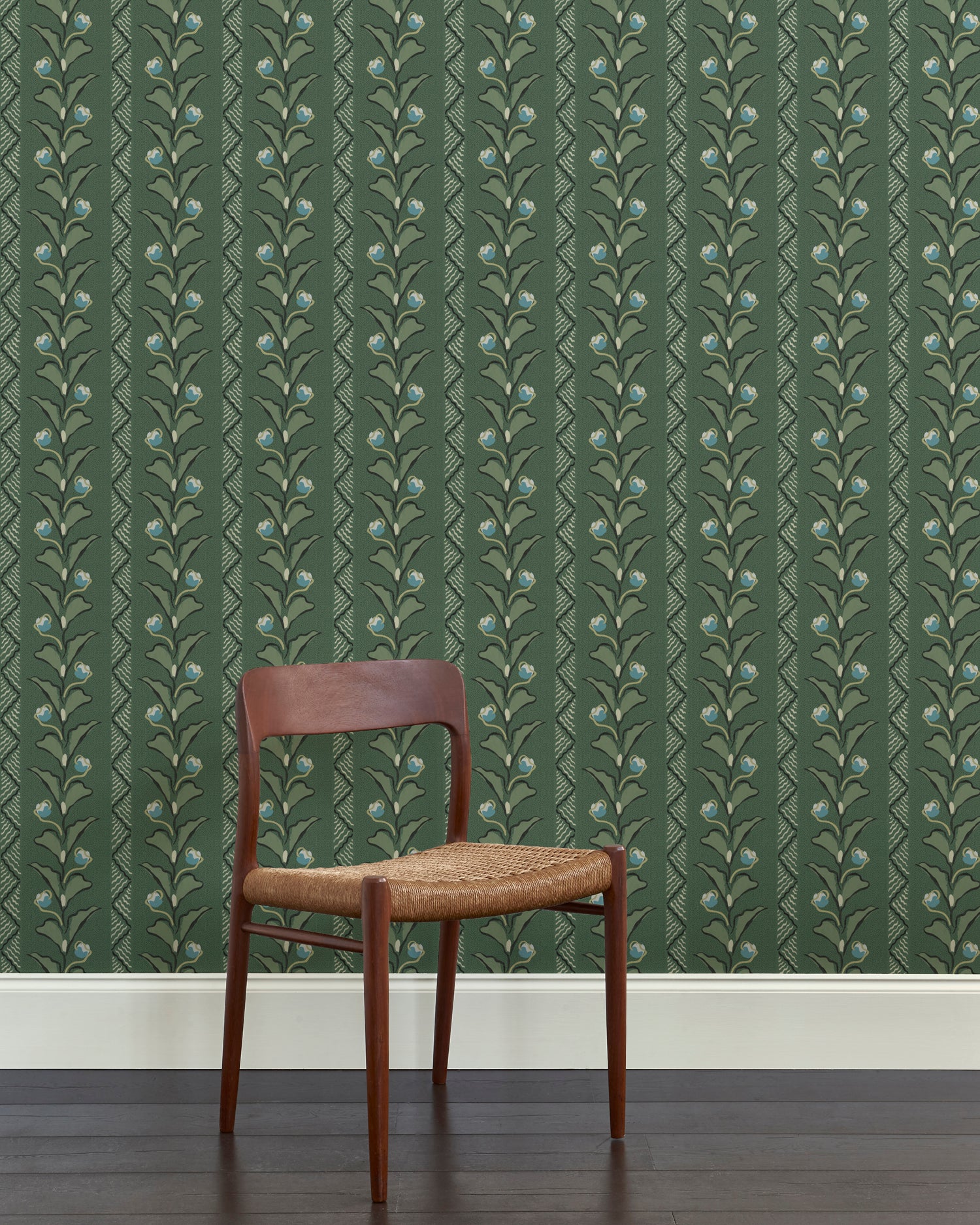 A wooden dining chair against a wallpaper in a painterly botanical stripe pattern in shades of green with blue accents.