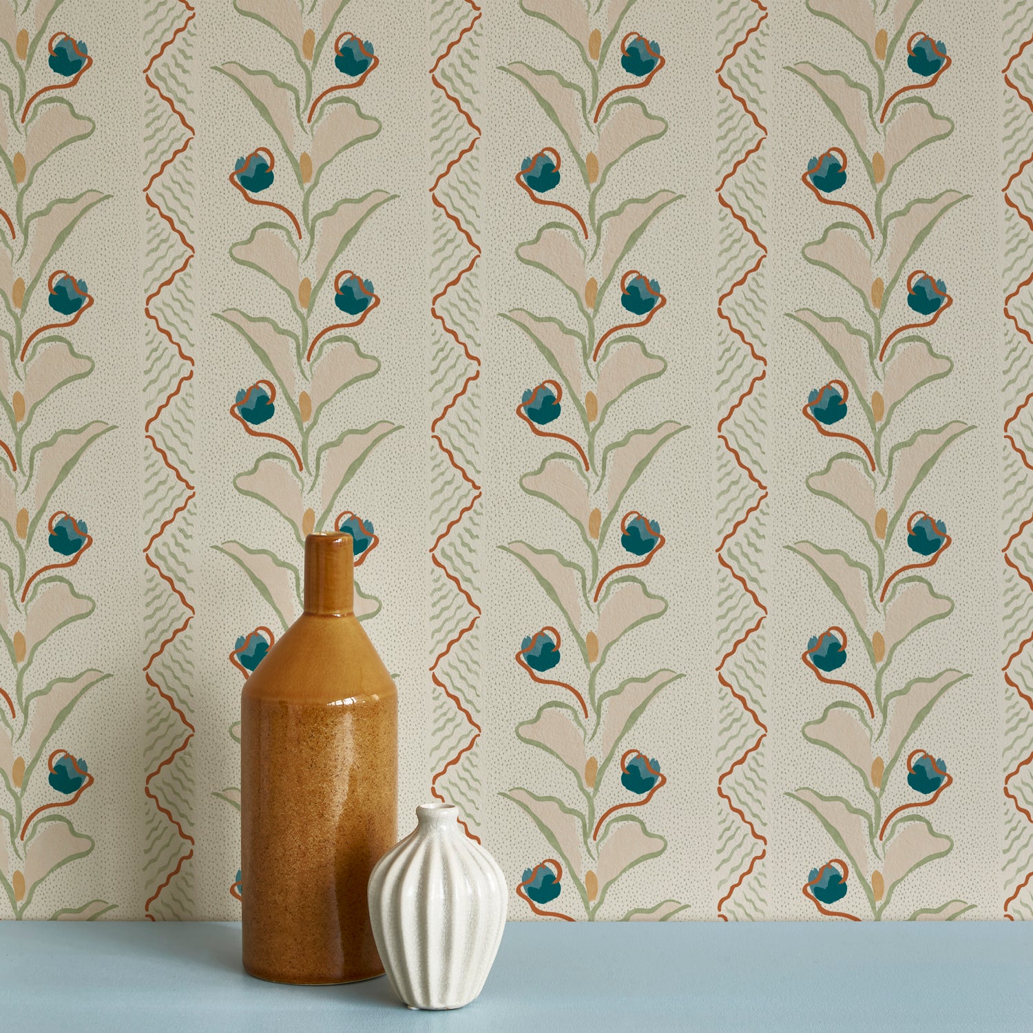 Brown and white ceramic vases against a wallpaper pattern with a playful botanical stripe in cream, pastel pink and accents of red and blue. 