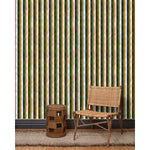 A wooden chair and end table in front of a wall papered in a curvy hand-painted stripe pattern in olive, sage, white and gold.