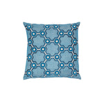 Square throw pillow with a geometric prism pattern embroidered in shades of blue on a white field.