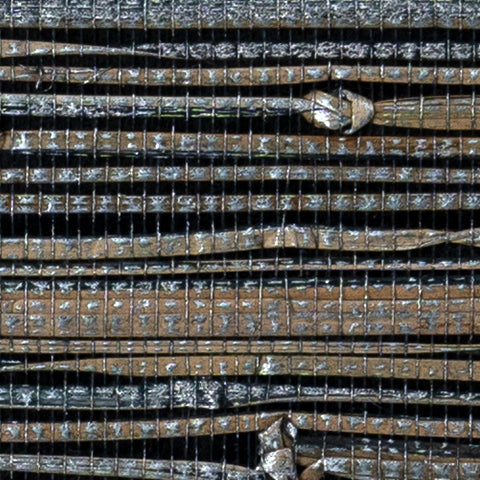 Detail of a metallic-rubbed jute grasscloth wallpaper in gray and tan on a glossy black paper.