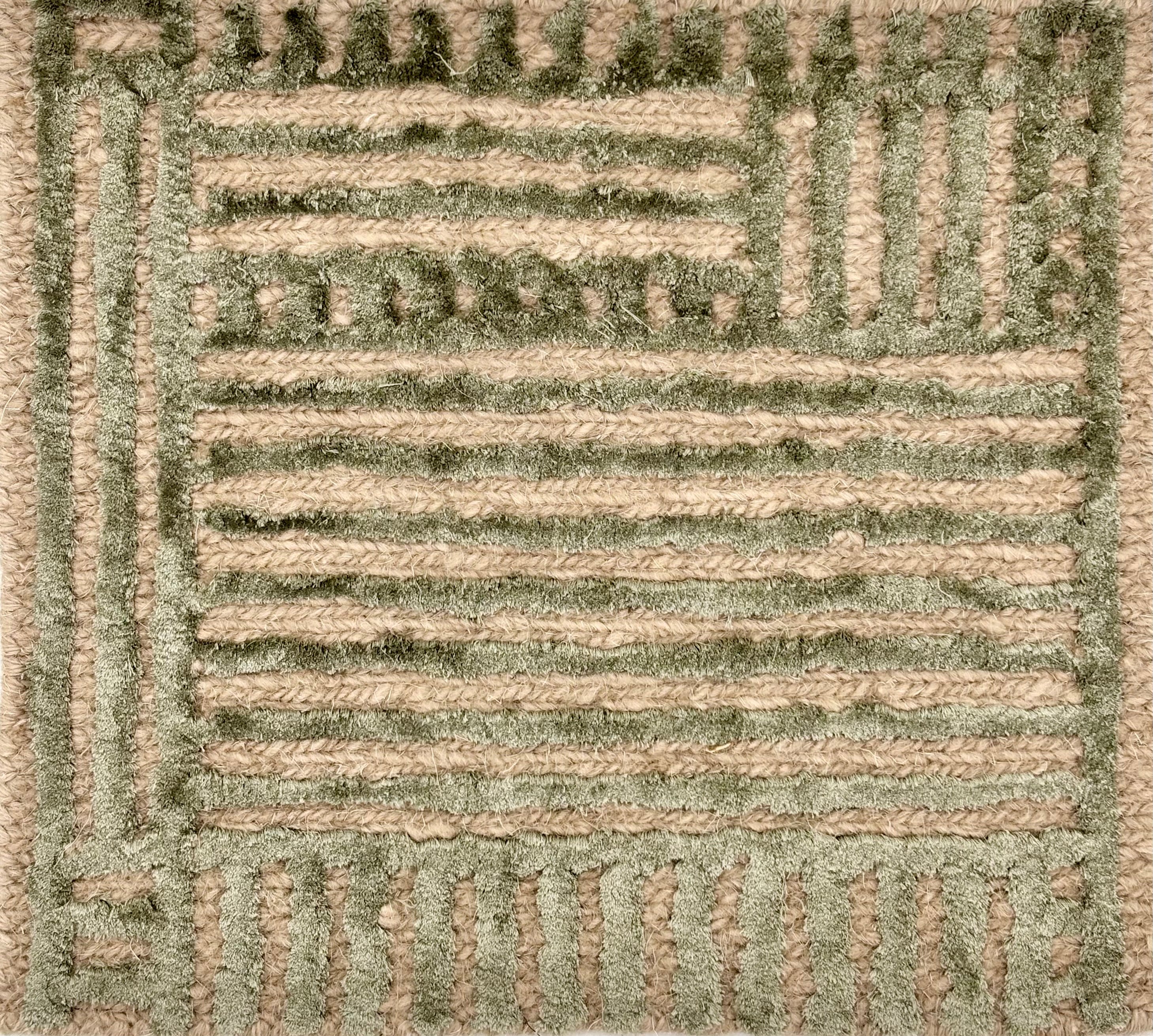 Detail of handknotted wool and silk with a raised green geometric pattern against a natural brown background.