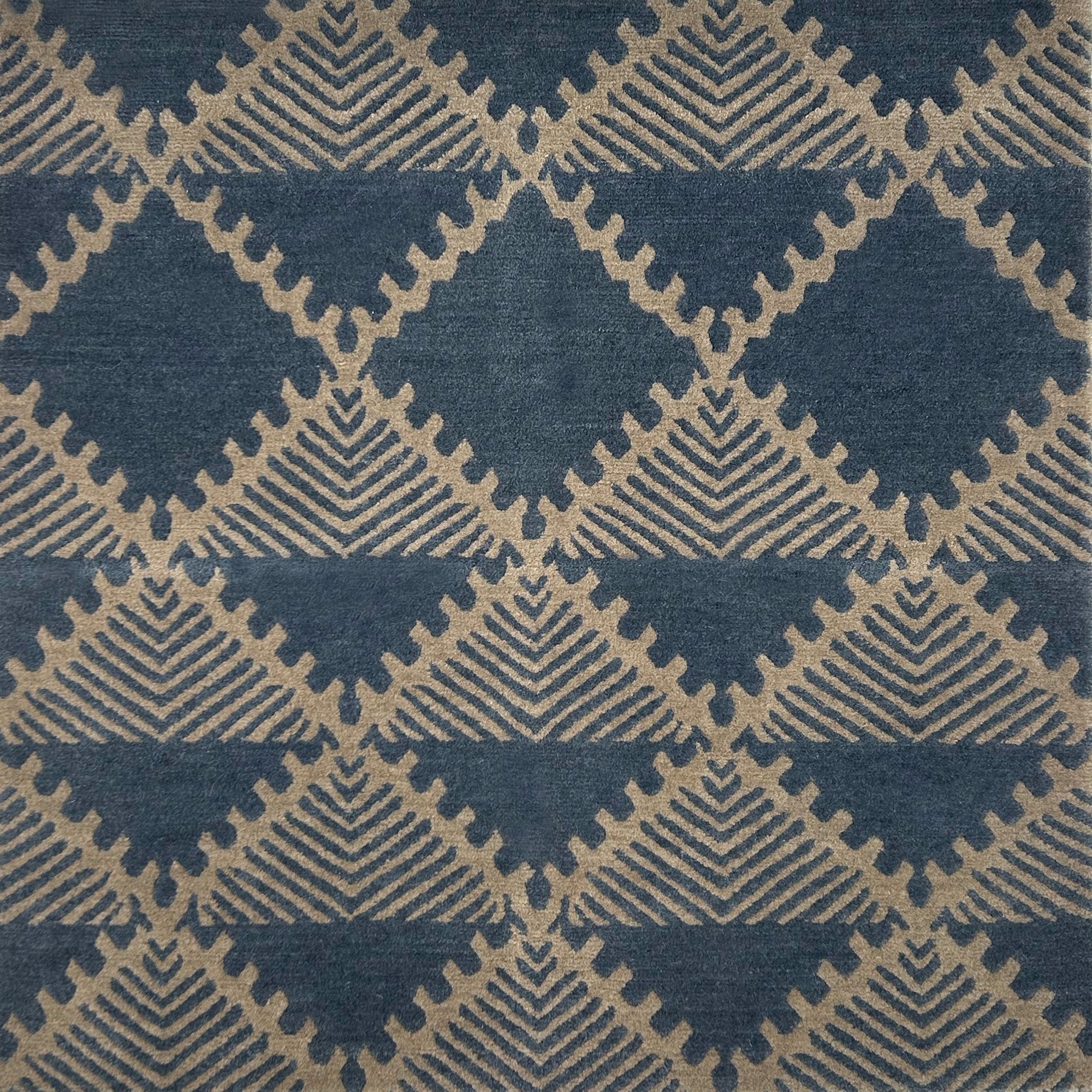 Handknotted rug in a geometric design in slate blue on a grey field. 