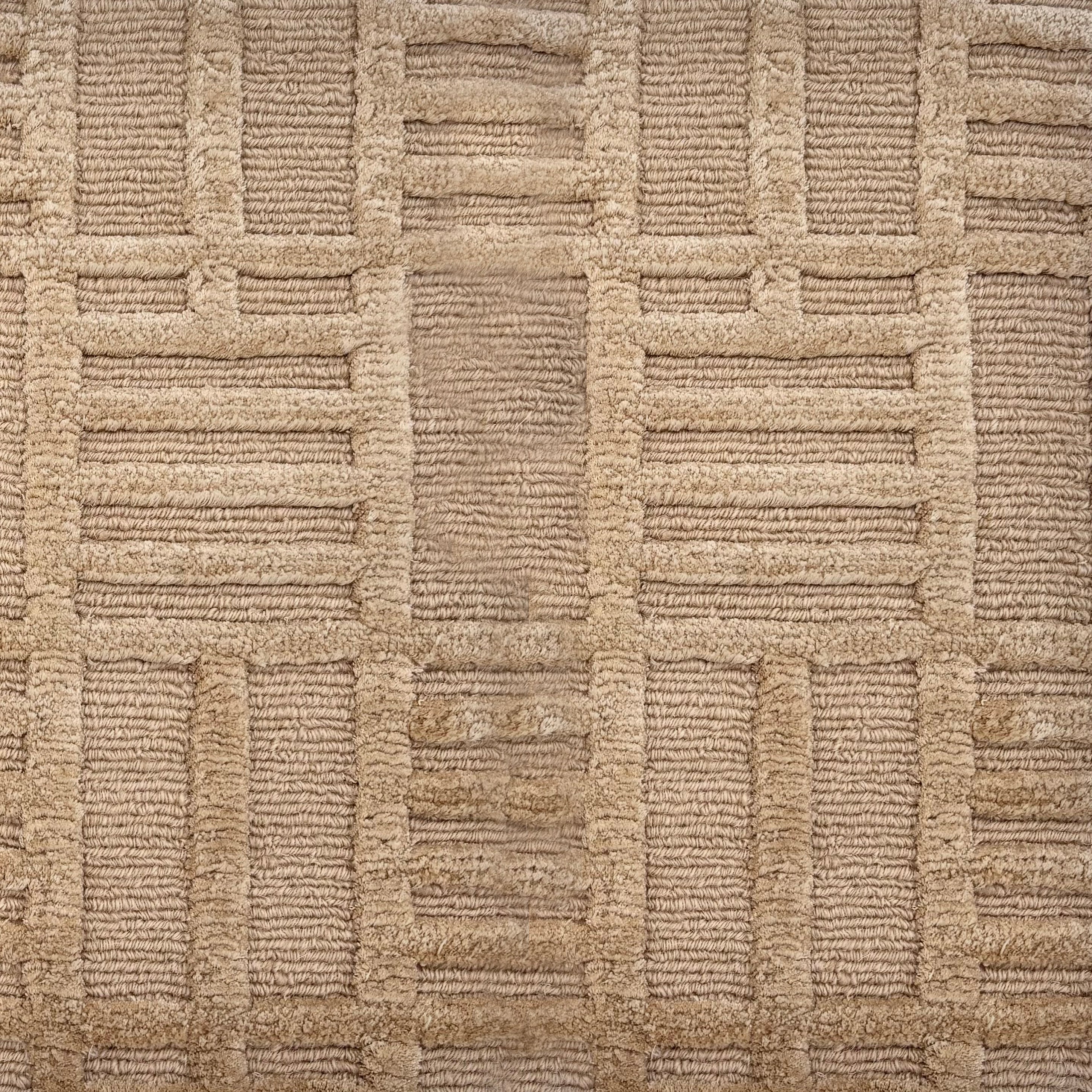 Detail of a Handknotted rug in beige with a raised linear pattern. 