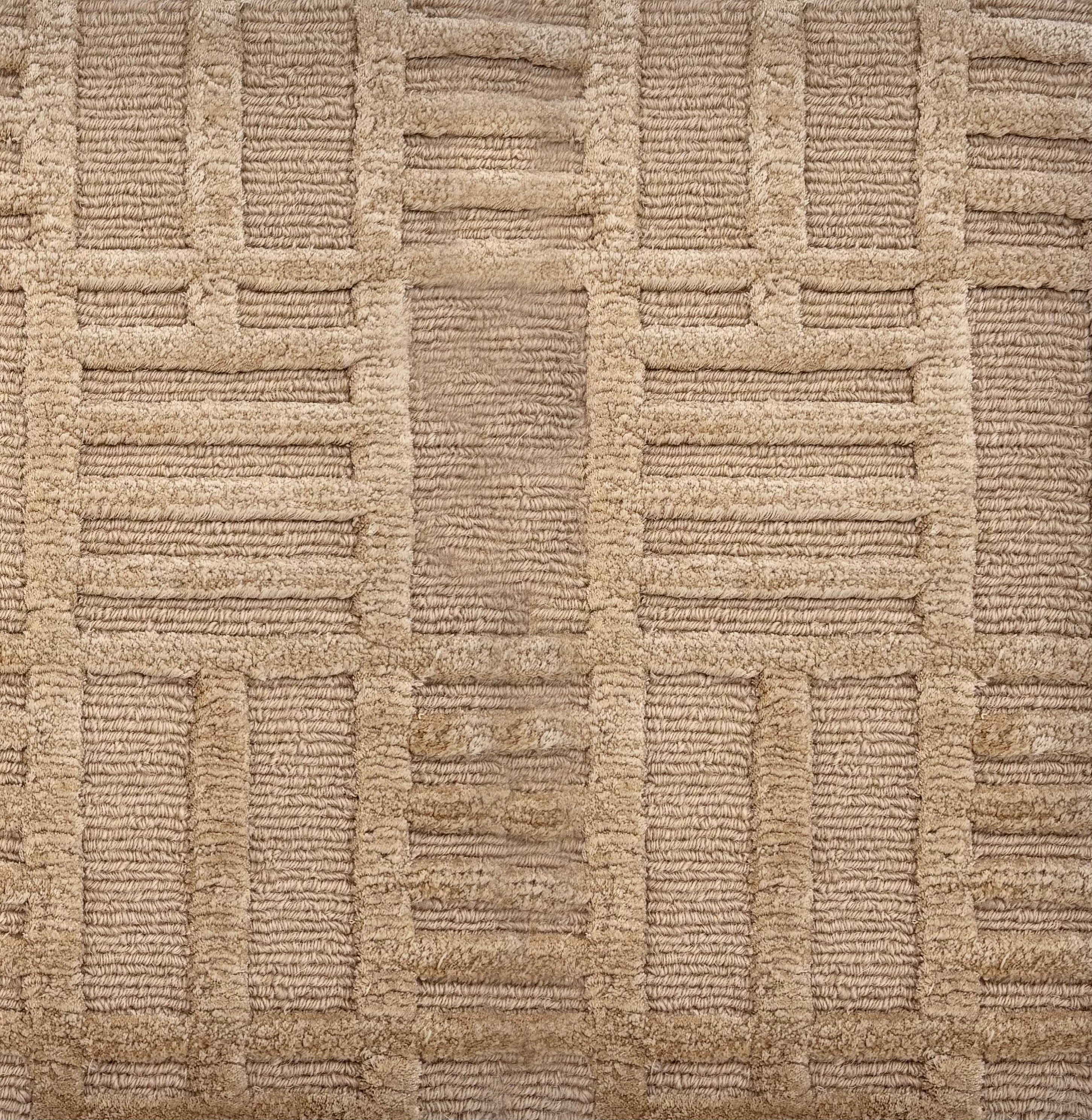 Detail of a Handknotted rug in beige with a raised linear pattern. 