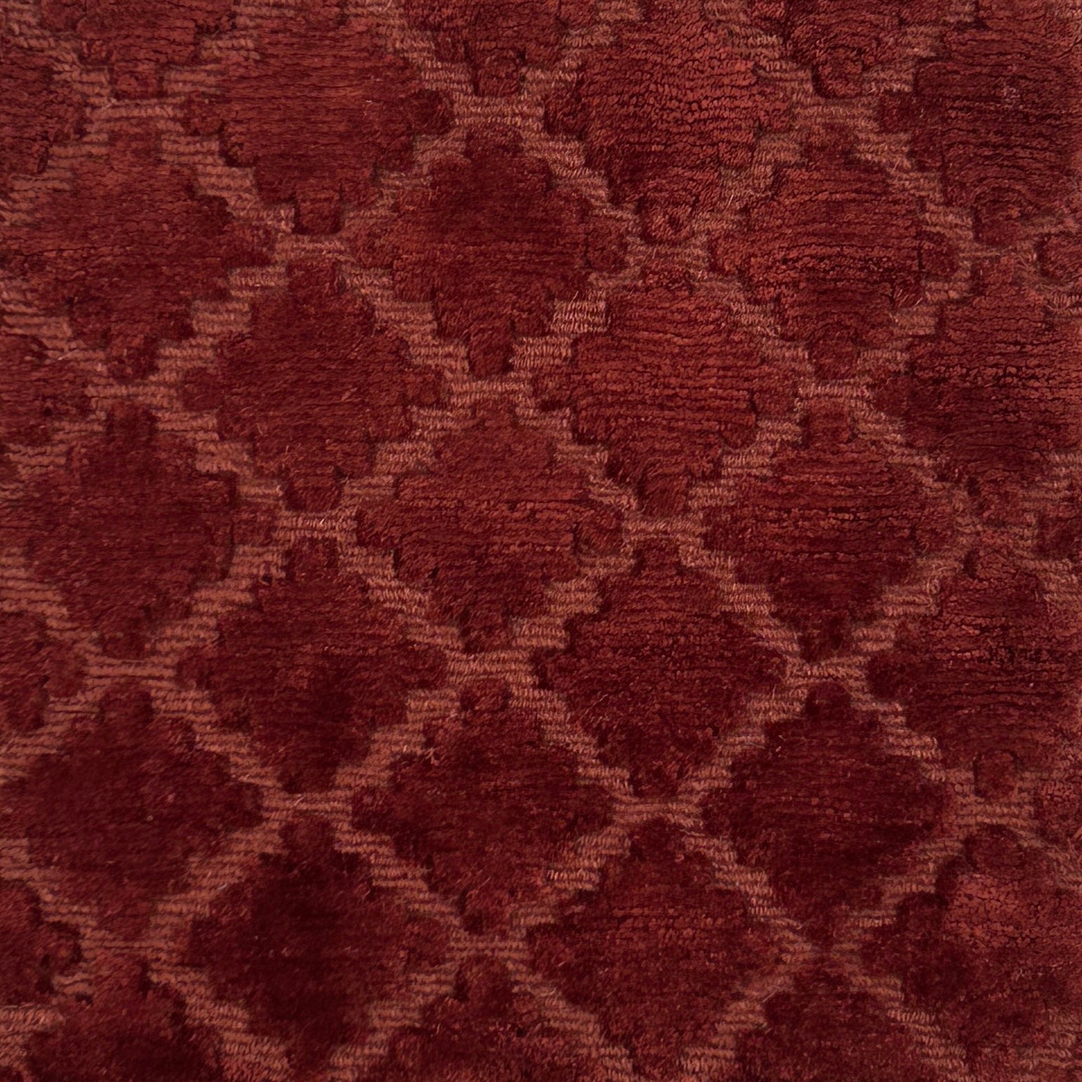 Close-up of a handknotted rust red fabric with a geometric pattern