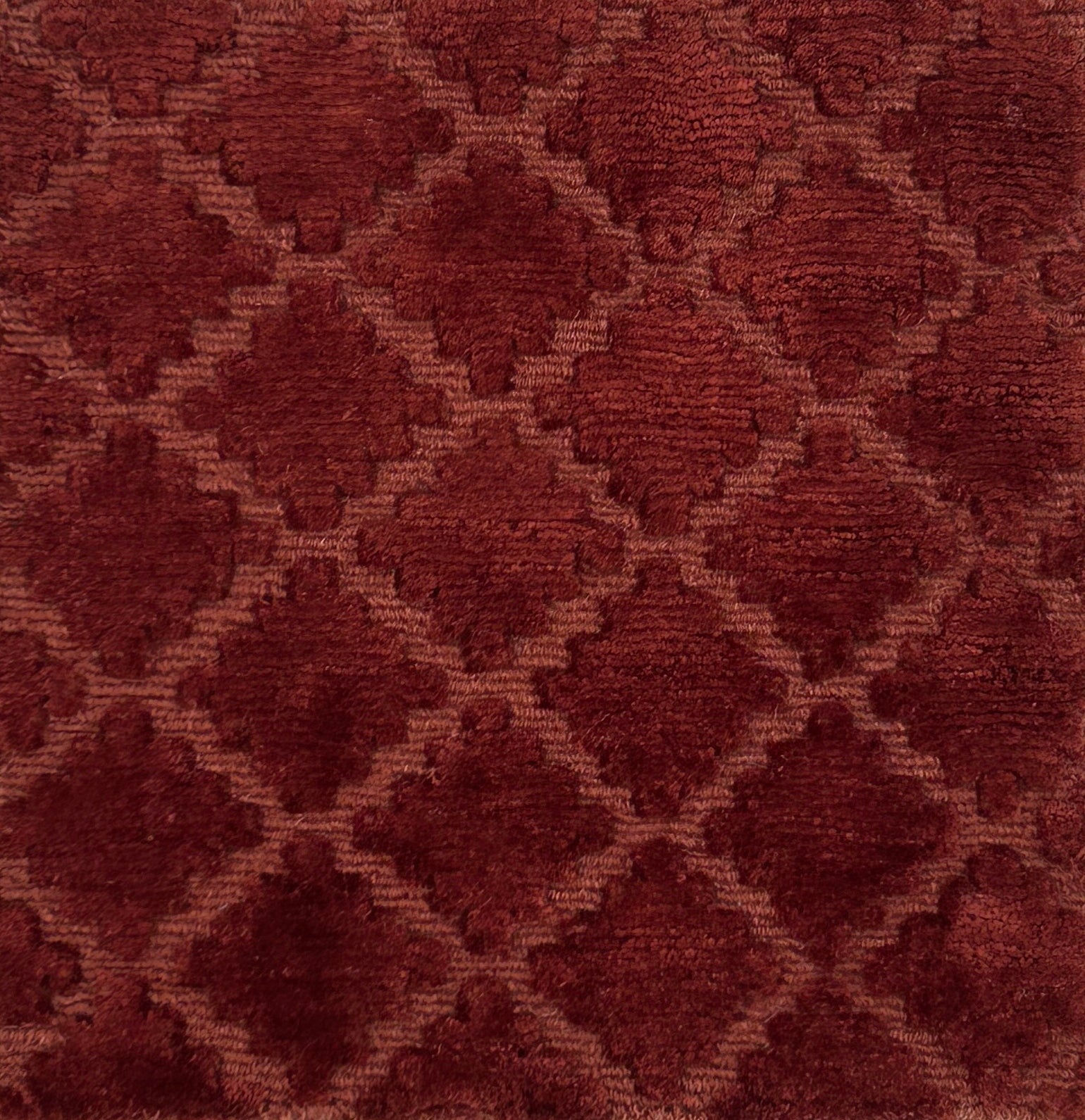 Close-up of a handknotted rust red fabric with a geometric pattern
