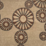Close-up of a handknotted rug with circular patterns in brown and beige.