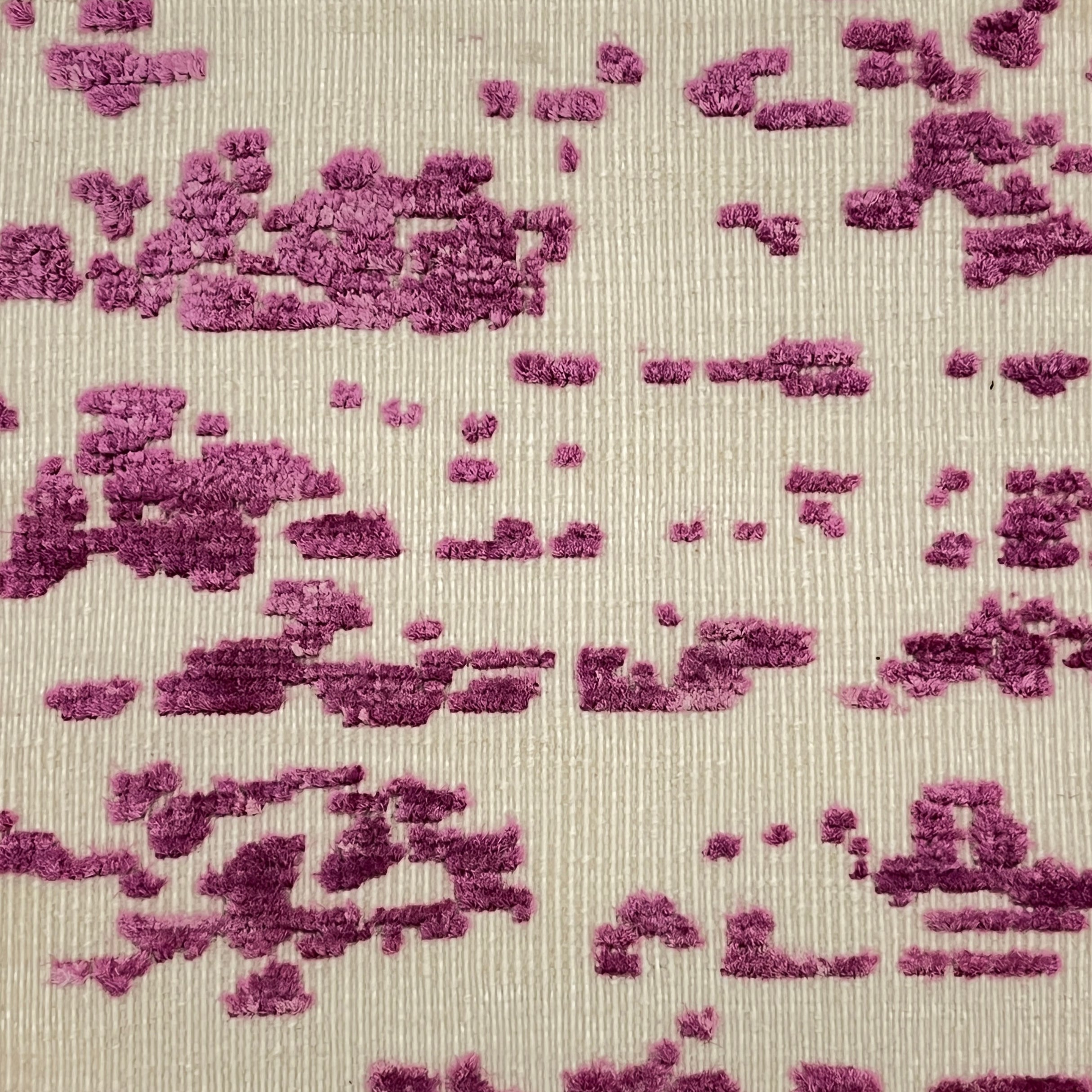 Textured rug with a pattern of raised purple shapes on a beige background