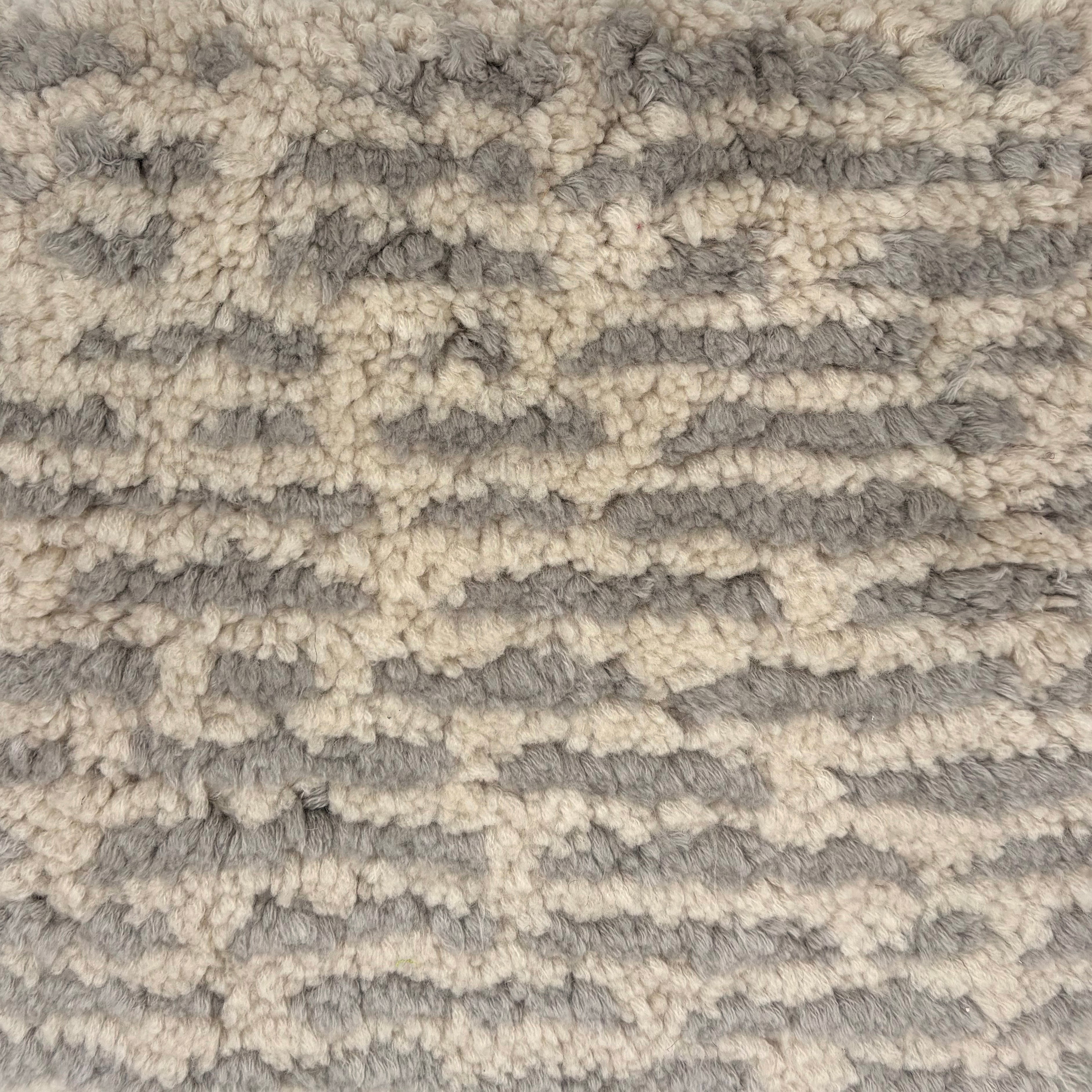 Handknotted Moroccan style rug in cream with gray dashed stripes.