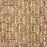 Detail of a handwoven rug in a raised geometric lattice in natural jute fibers.