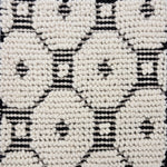 Detail of a handknotted dimensional rug in a geometric pattern in black and white.