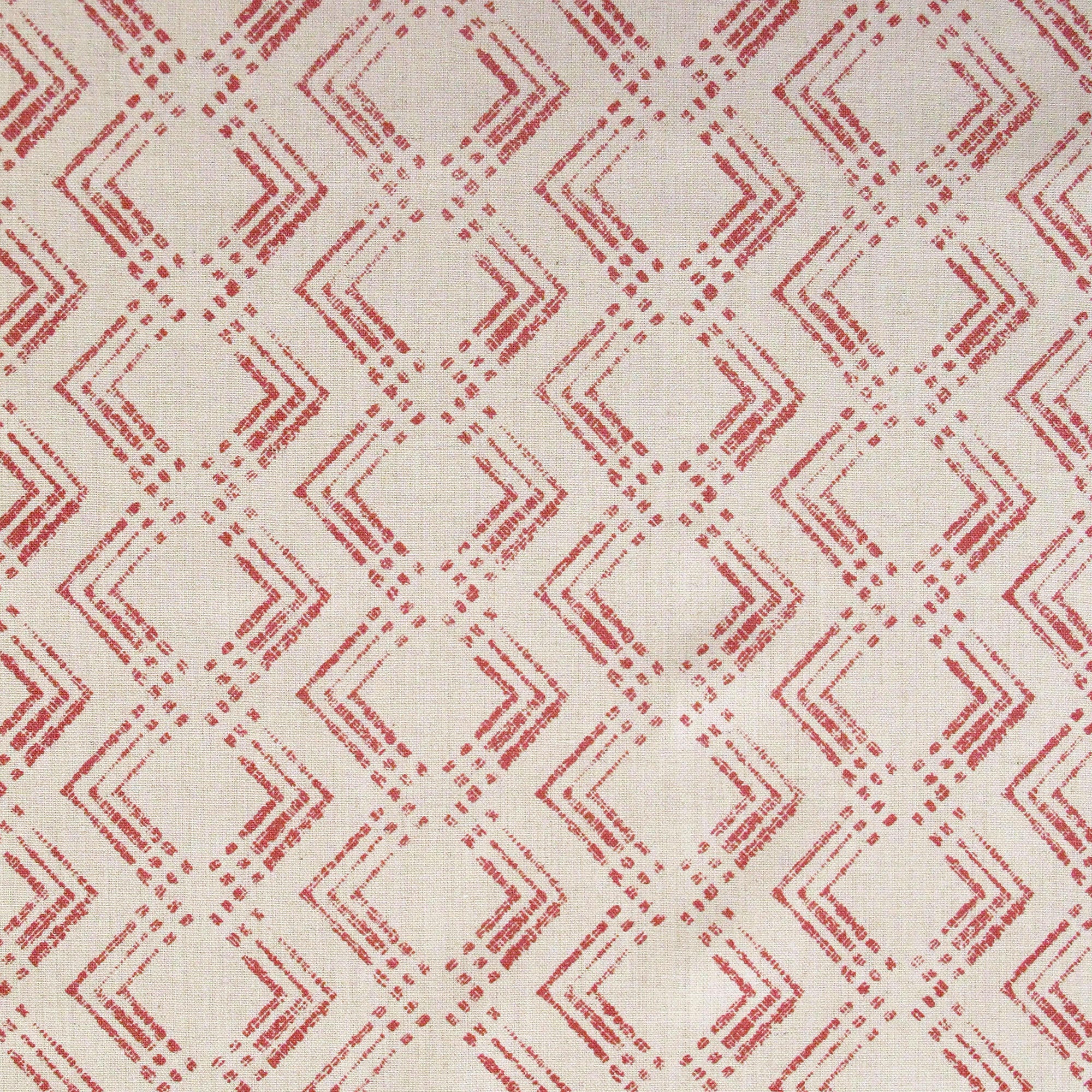 Fabric in a diamond grid pattern in coral on a tan field.