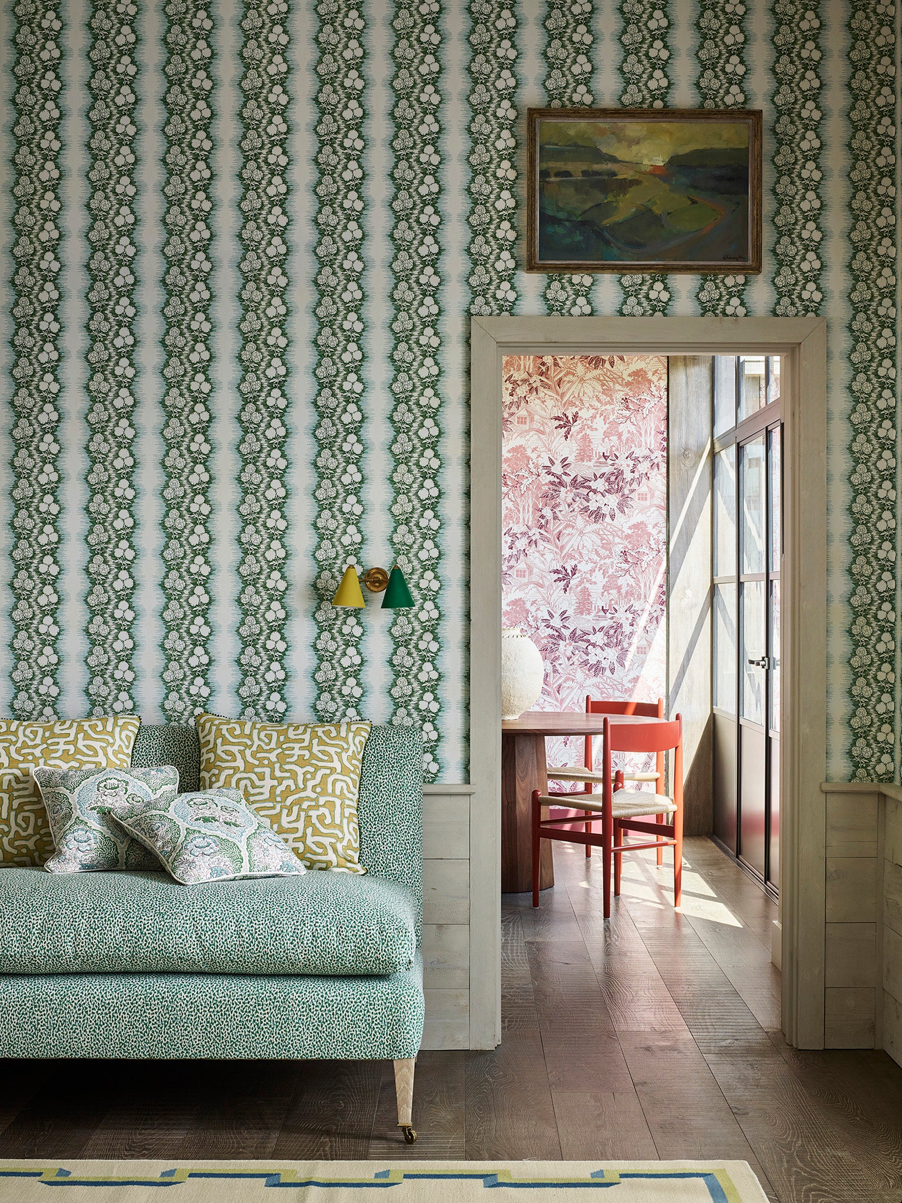 Shabby-chic living room with a statement wall papered in a botanical stripe print in blue, sage and white.