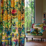 A living space with long curtains and an armchair, both in the same painterly multicolor botanical print.