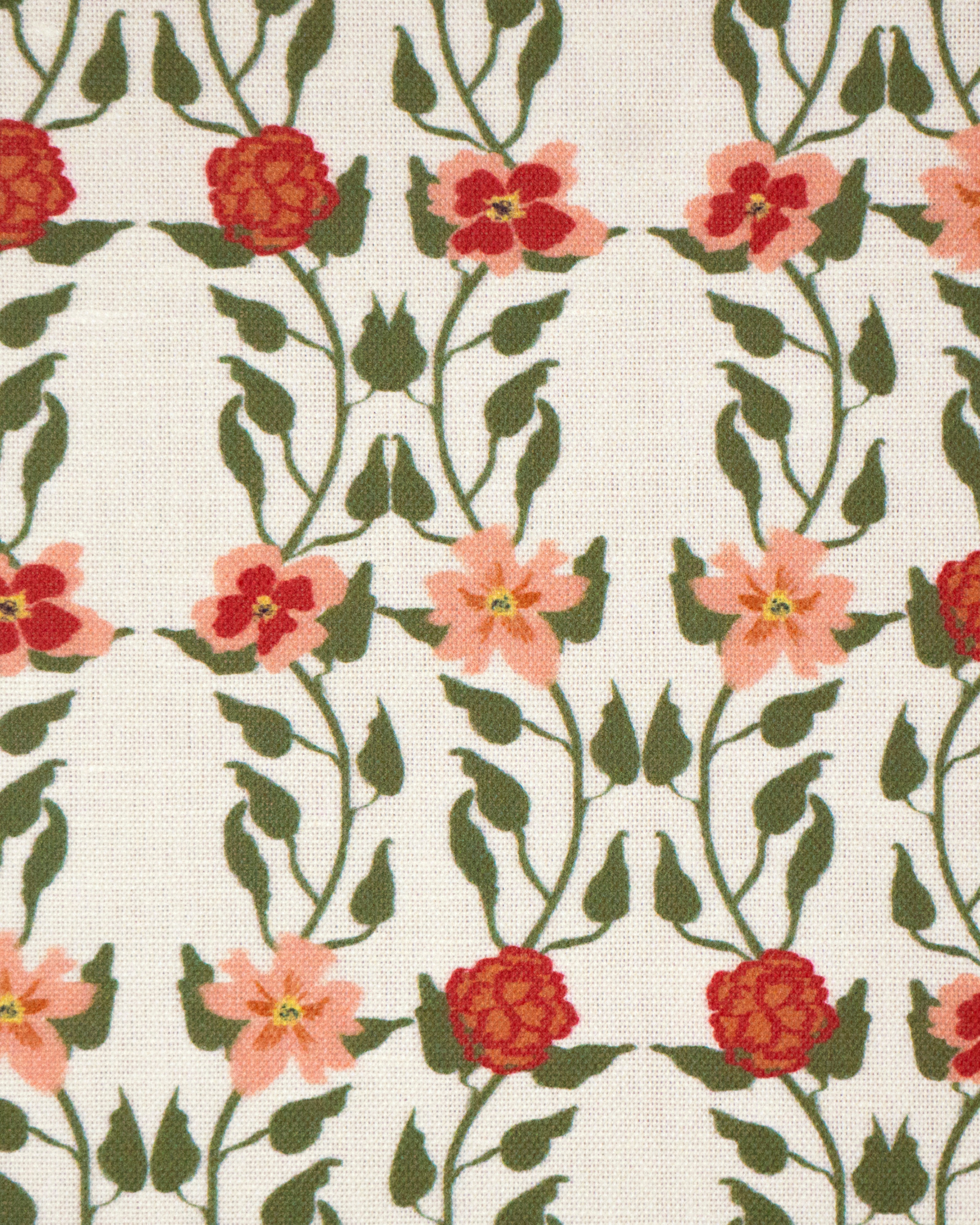 Detail of fabric in a linear floral print in red, orange and green on a white field.