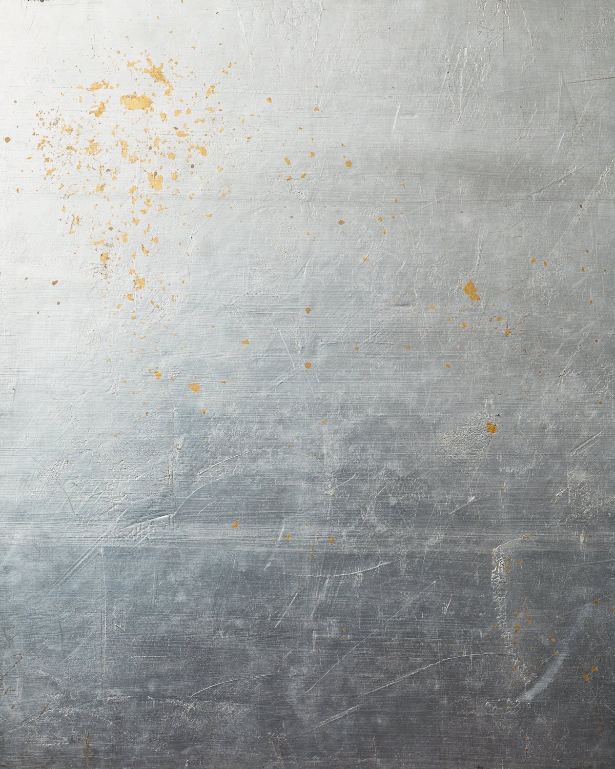 Detail of wallpaper in a minimal gold paint splatter print on a silver field.