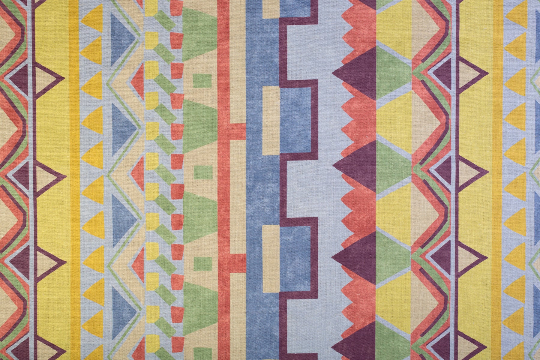 Detail of fabric in a playful geometric stripe in a rainbow of pastel shades.