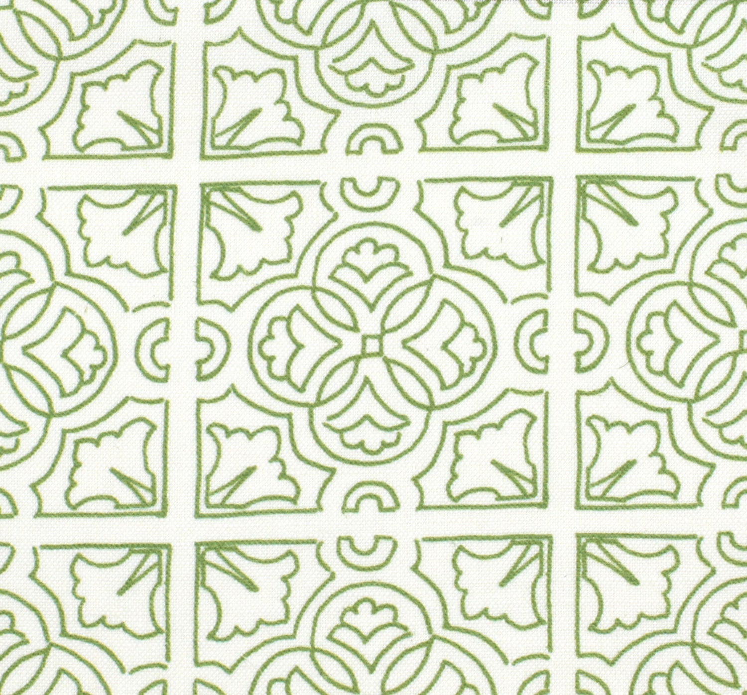 Detail of fabric in a damask lattice print in green on a white field.