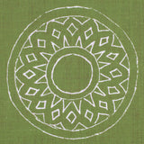 Detail of fabric in a repeating circular geometric print in white on a green field.